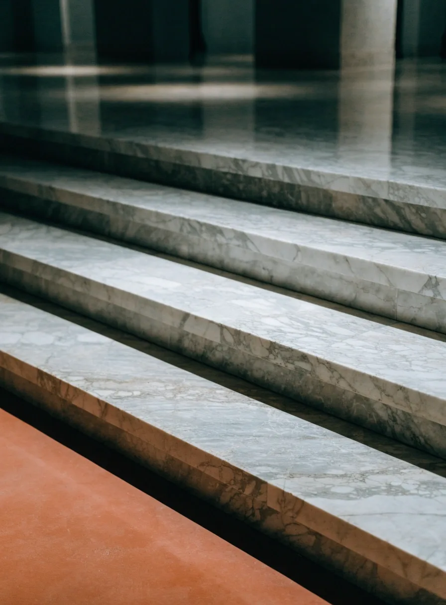 Marble stair detail with deep shadow under the step and terracotta floor edge