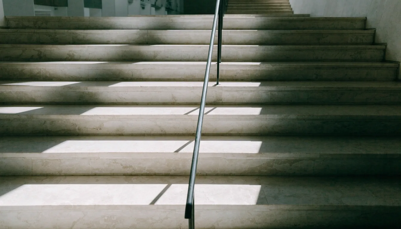 Marble museum stairs with hard noon light across the treads