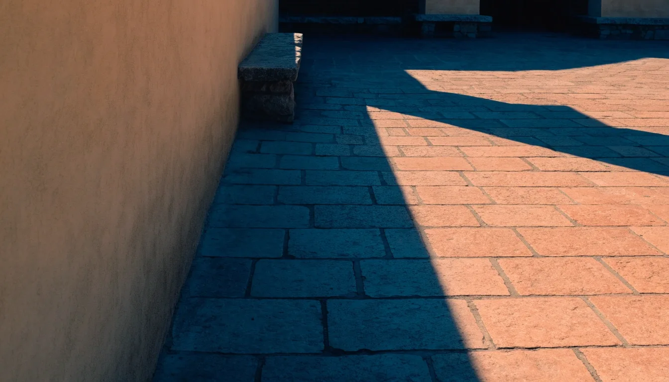 Shadowed museum courtyard wall meeting a sunlit stone floor at noon