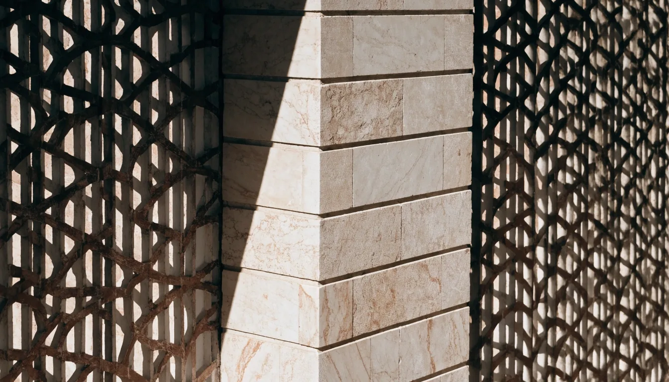 Coursed marble and terracotta lattice wall of the Museé Yves Saint Laurent Marrakech exterior under hard noon light
